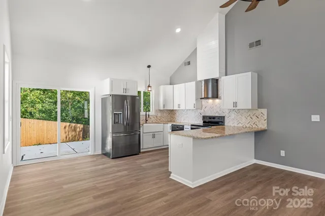 a kitchen with a refrigerator and a stove top oven