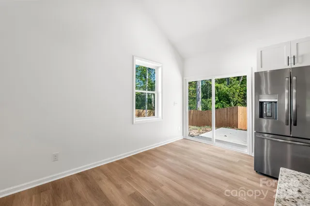 a view of a kitchen with wooden floor and a refrigerator