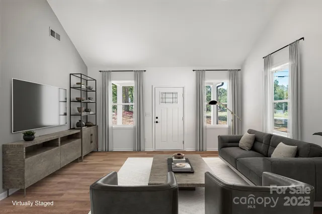 a living room with furniture a flat screen tv and a window