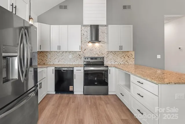a kitchen with stainless steel appliances granite countertop a stove and a refrigerator