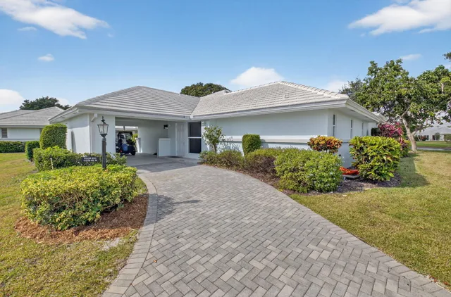 a front view of a house with a yard and potted plants