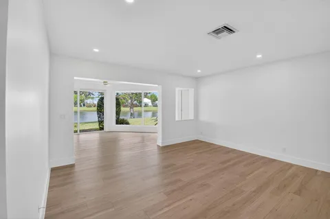 a living room with hardwood floor and a large window