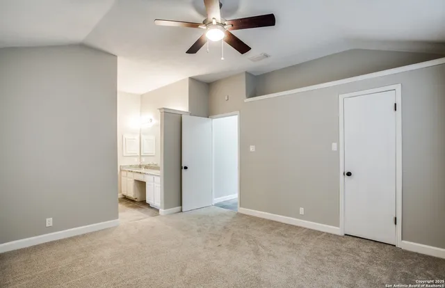 an empty room with closet and a ceiling fan