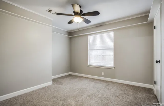 an empty room with a window and a ceiling fan
