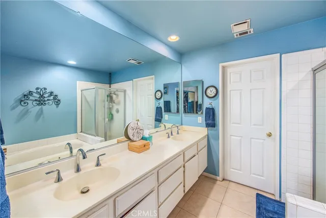 a bathroom with a double vanity sink mirror and shower