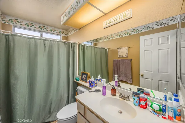 a bathroom with a sink vanity mirror and toilet