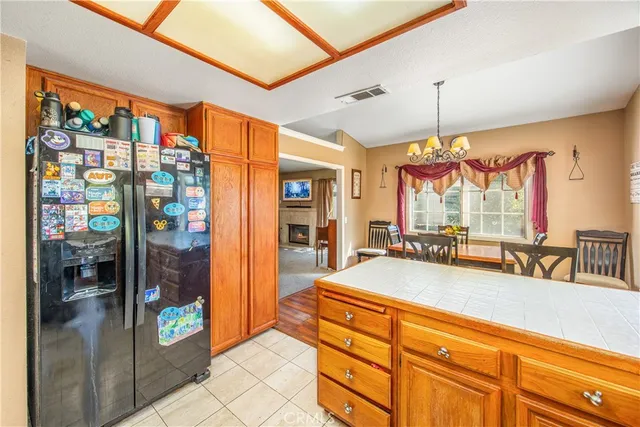 a living room with stainless steel appliances kitchen island granite countertop a refrigerator and a sink