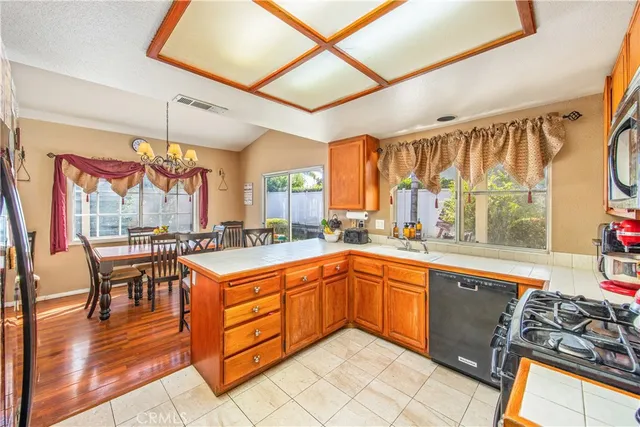 a kitchen with stainless steel appliances granite countertop sink stove and wooden cabinets
