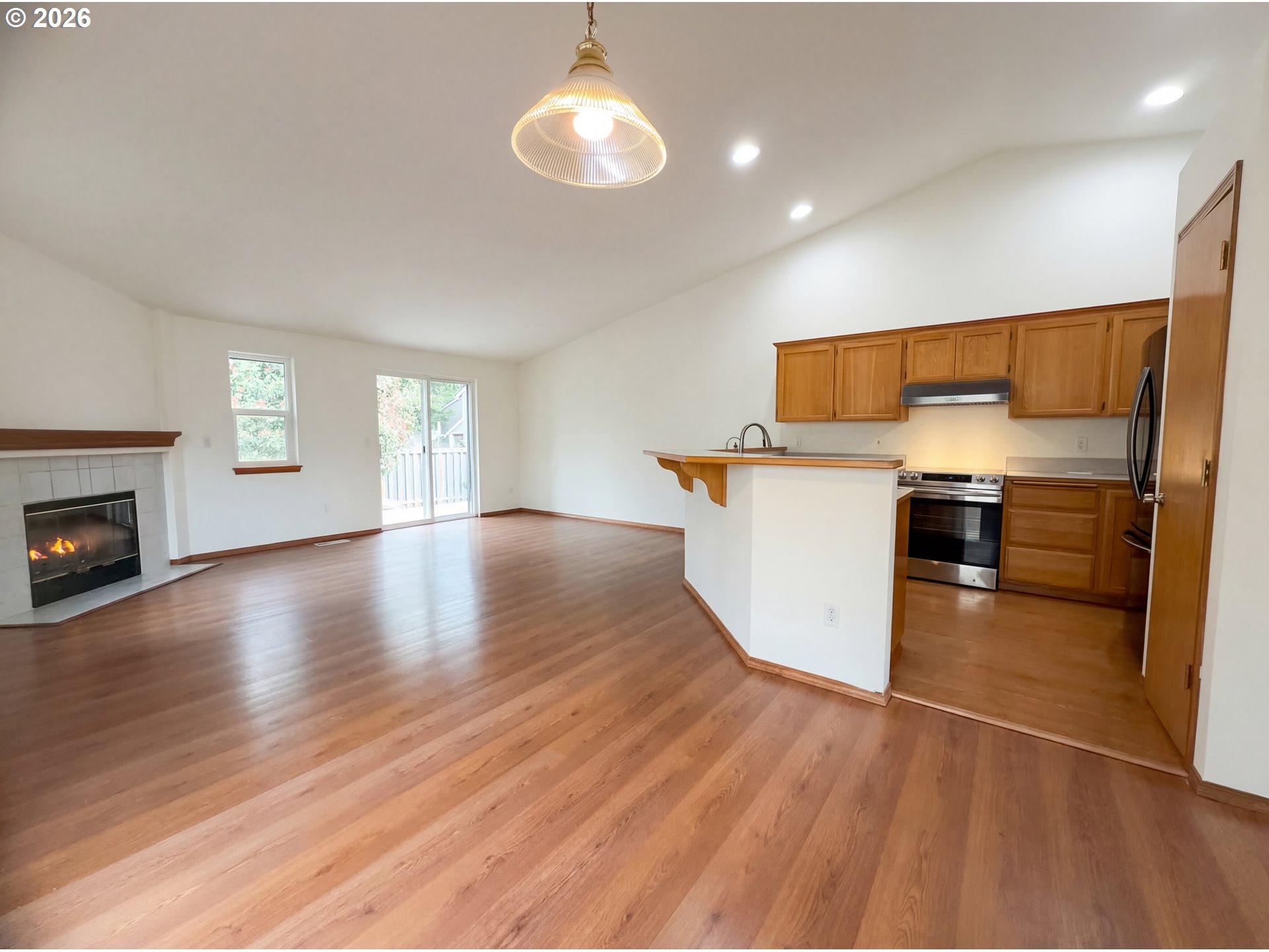 8641 Northeast Windstone Street Beaverton, OR 97006 - Photo 14 of 18 a kitchen with granite countertop a stove and a wooden floors