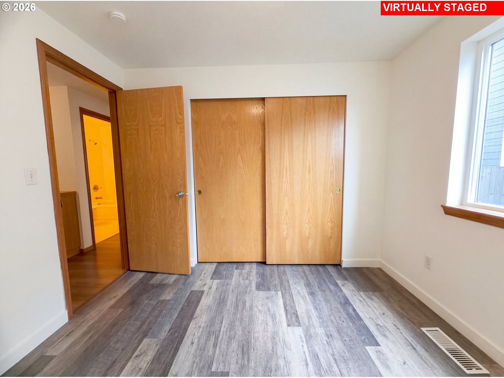 8641 Northeast Windstone Street Beaverton, OR 97006 - Photo 4 of 18 an empty room with wooden floor and a window