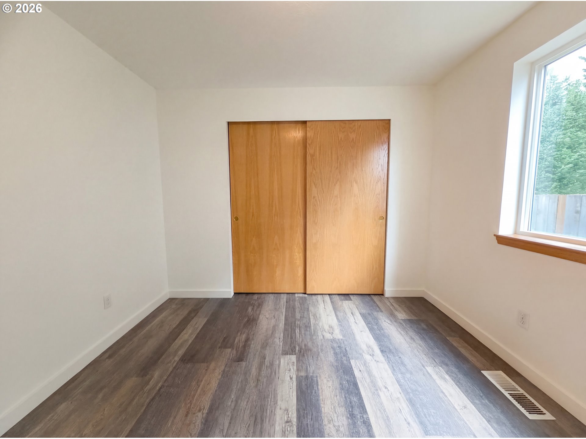 8641 Northeast Windstone Street Beaverton, OR 97006 - Photo 9 of 18 a view of an empty room with wooden floor and a window
