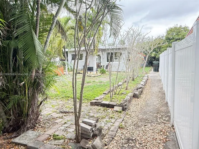 a view of a yard with plants and trees