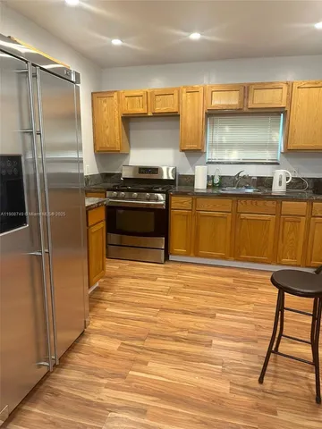 a kitchen with stainless steel appliances granite countertop a refrigerator and a stove top oven