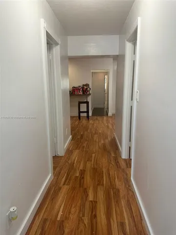 a view of a bedroom with wooden floor and furniture