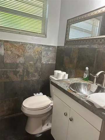 a bathroom with a toilet a sink and mirror