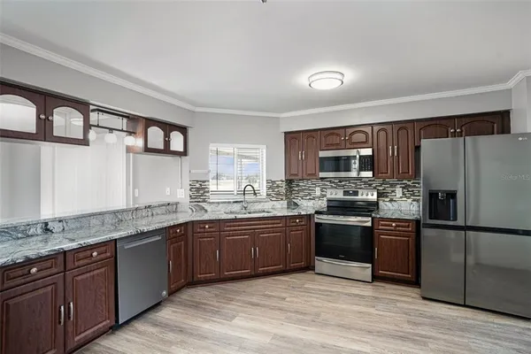a kitchen with stainless steel appliances granite countertop a sink stove and refrigerator