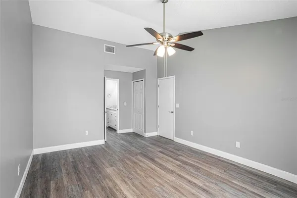 a view of an empty room with wooden floor