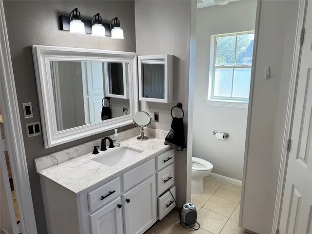 a bathroom with a sink toilet and mirror