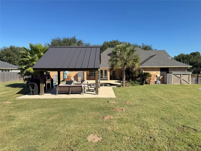a view of a house with table and chairs under an umbrella