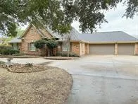 a front view of house with yard and trees around