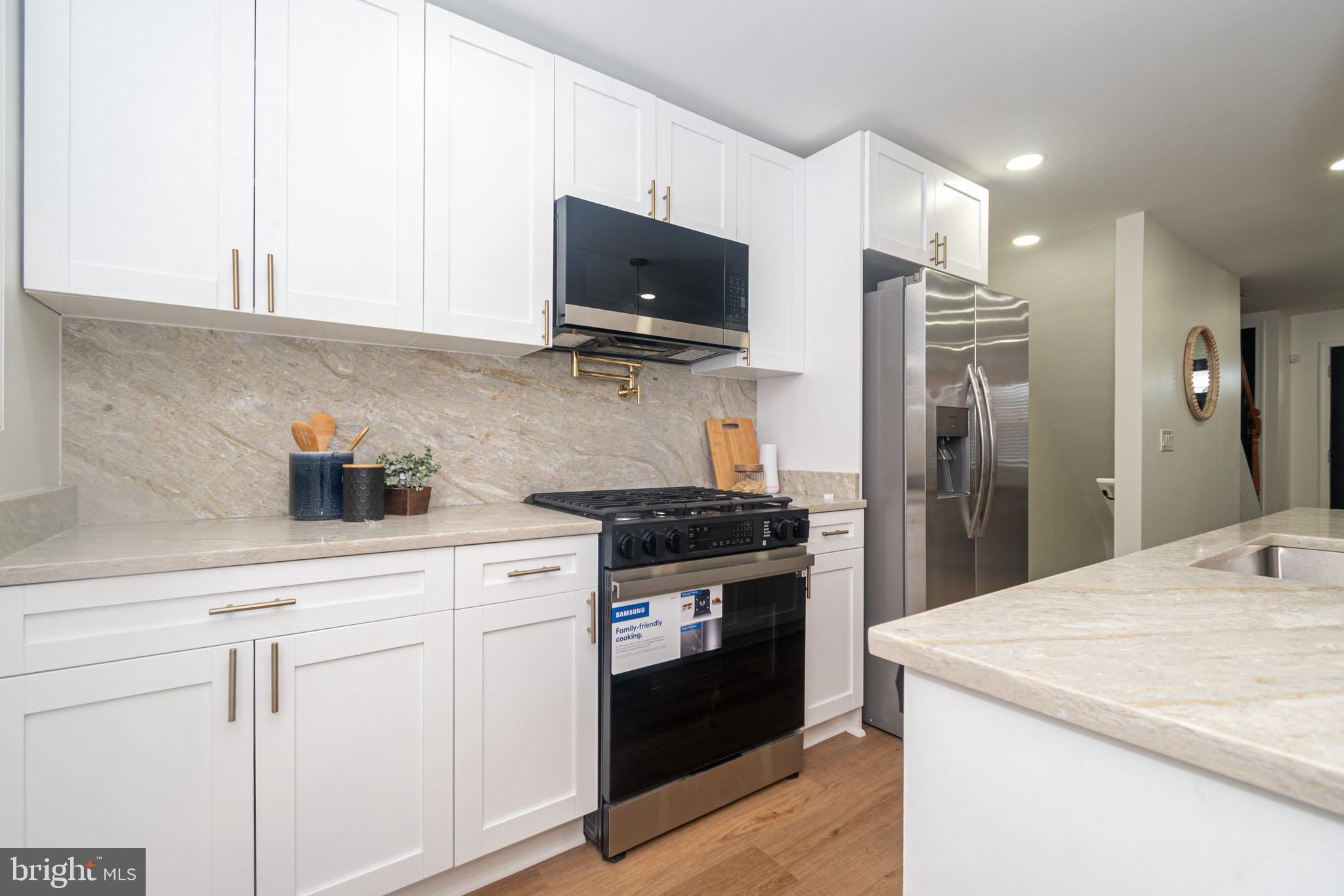 2560 Cecil Avenue Baltimore, MD 21218 - Photo 3 of 11 a kitchen with stainless steel appliances granite countertop a stove a refrigerator and a sink