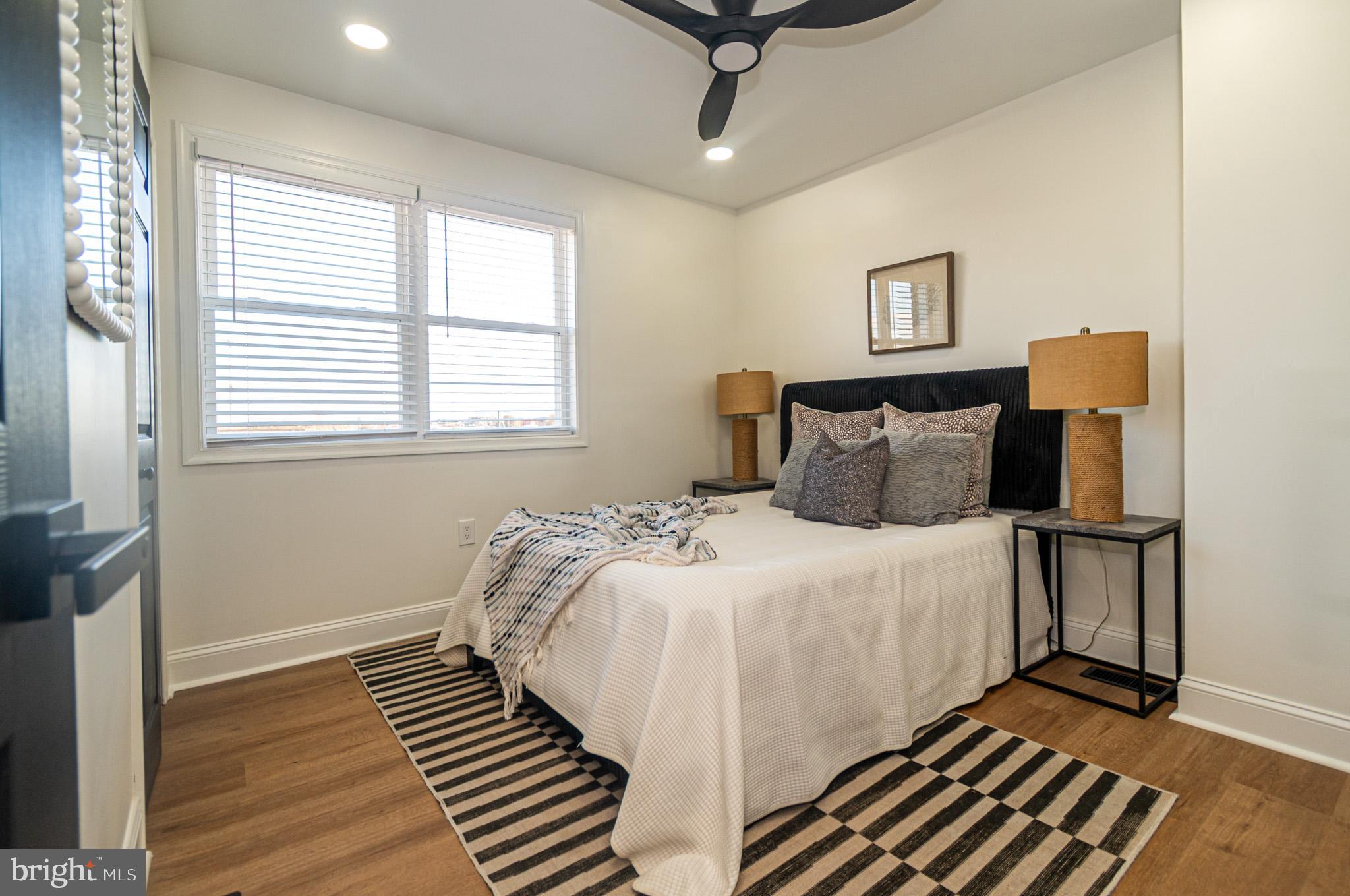 2560 Cecil Avenue Baltimore, MD 21218 - Photo 6 of 11 a bedroom with a bed and wooden floor