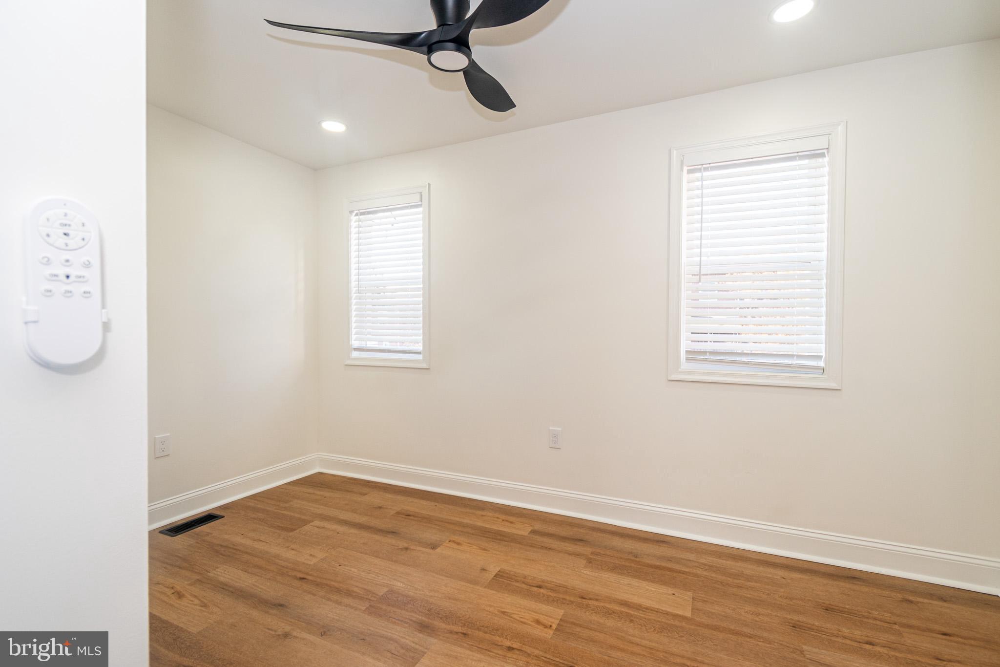 2560 Cecil Avenue Baltimore, MD 21218 - Photo 9 of 11 an empty room with wooden floor cabinet and windows