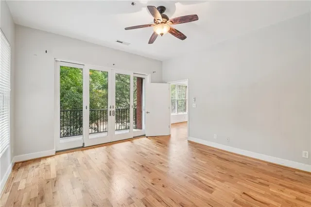 a view of an empty room with a window and wooden floor