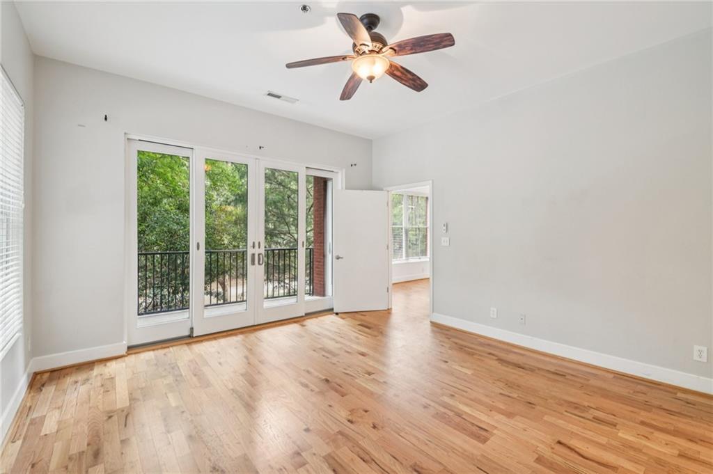 384 Ralph McGill Boulevard Northeast, Unit 105 Atlanta, GA 30312 - Photo 11 of 29 a view of an empty room with a window and wooden floor