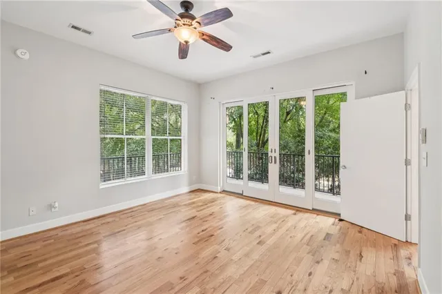 a view of an empty room with a window and wooden floor