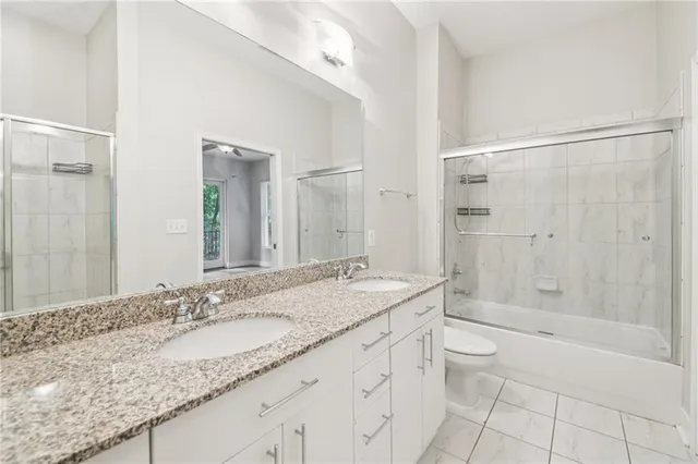 a bathroom with a granite countertop sink a toilet and shower