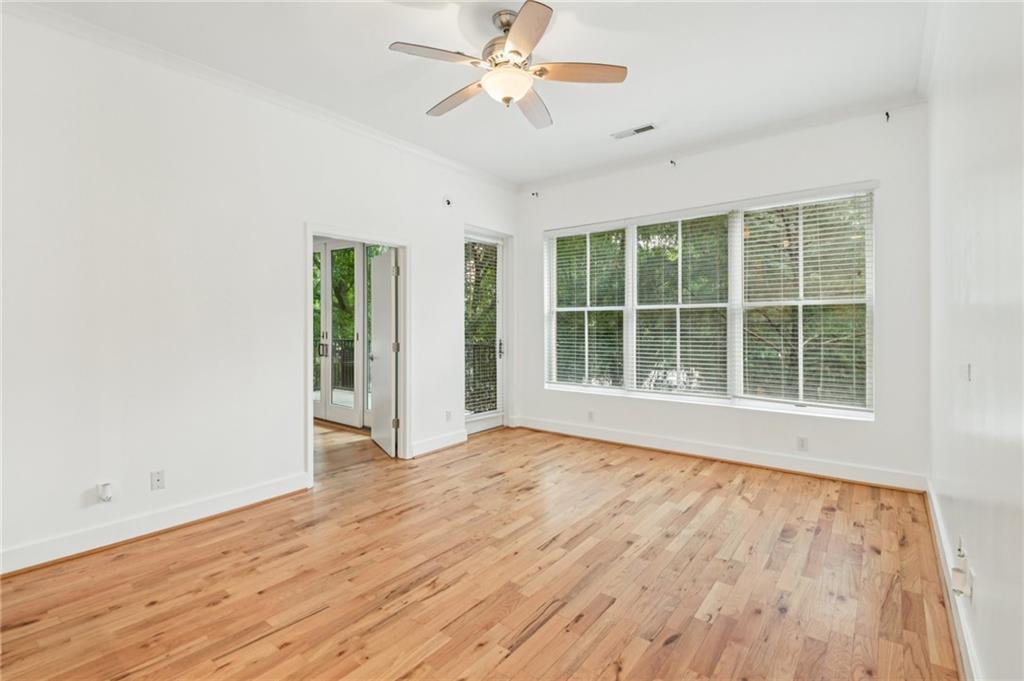 384 Ralph McGill Boulevard Northeast, Unit 105 Atlanta, GA 30312 - Photo 7 of 29 an empty room with wooden floor and windows