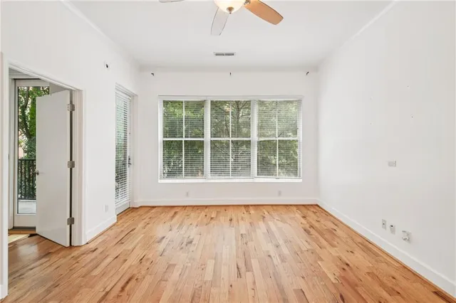 an empty room with wooden floor and windows