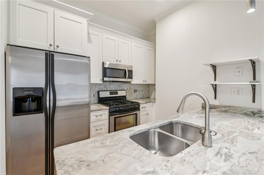384 Ralph McGill Boulevard Northeast, Unit 105 Atlanta, GA 30312 - Photo 10 of 29 a kitchen with stainless steel appliances granite countertop a sink a refrigerator and a sink