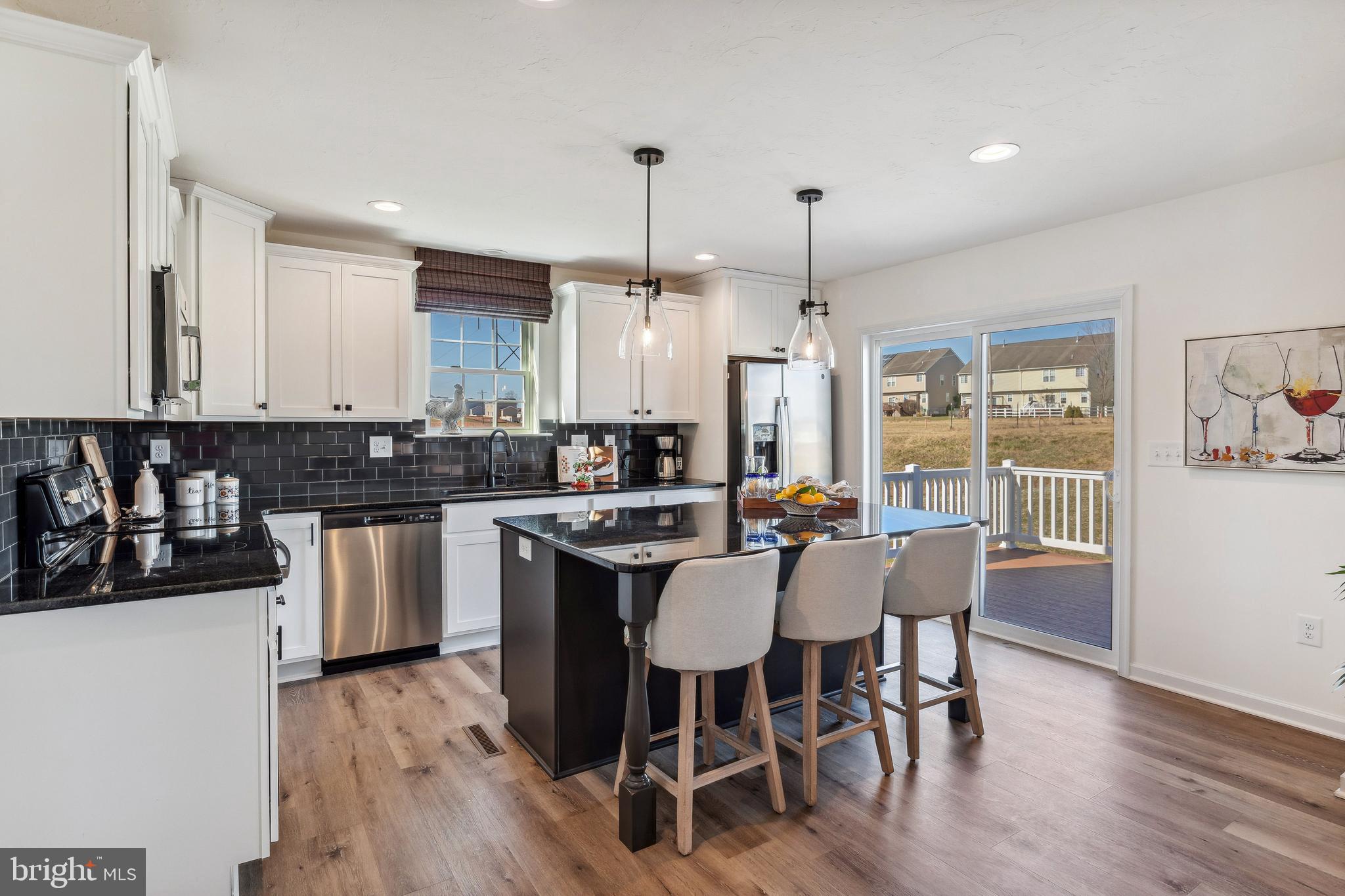 2601 Village Road Dover, PA 17315 - Photo 3 of 20 a kitchen with stainless steel appliances kitchen island granite countertop a dining table chairs and white cabinets