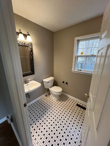 an empty room with wooden floor and chandelier