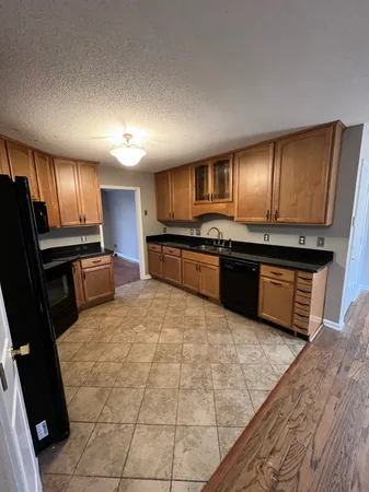 a view of a kitchen with wooden floor a sink and dishwasher