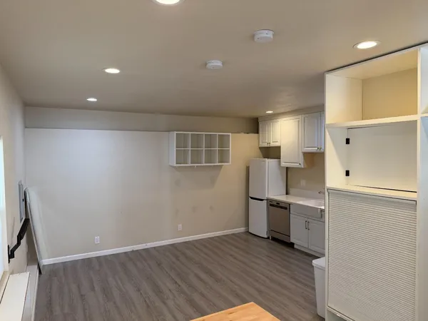an empty room with wooden floor and electronic appliances