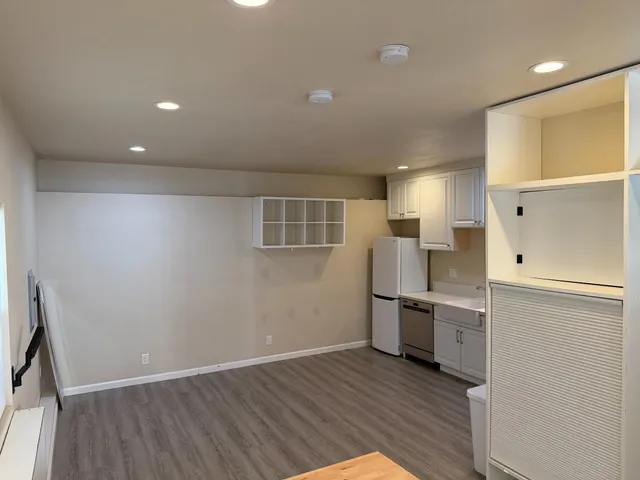 an empty room with wooden floor and electronic appliances
