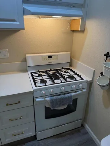 a stove top oven sitting inside of a kitchen