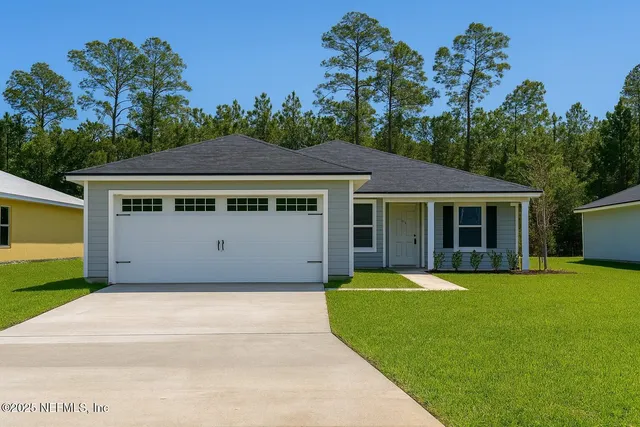 a front view of a house with a yard and trees