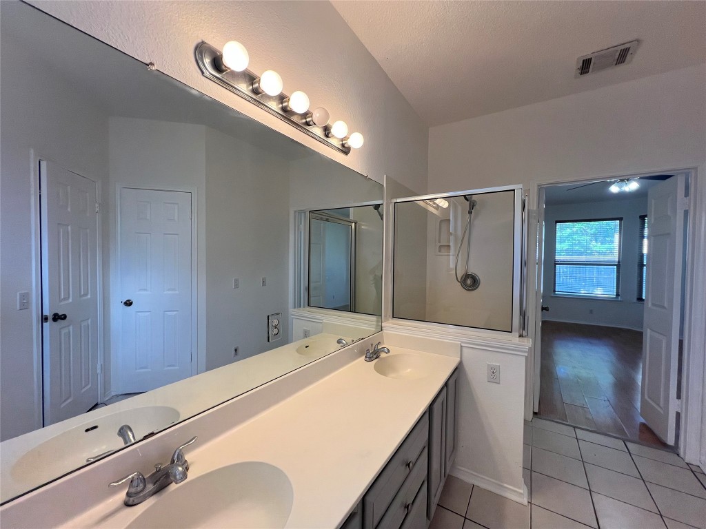 1525 Natural Bridge Lane Pflugerville, TX 78660 - Photo 11 of 15 a spacious bathroom with a granite countertop sink a mirror and shower