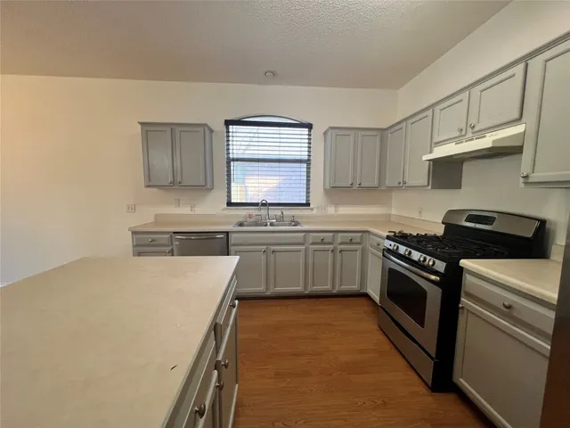 a kitchen with stainless steel appliances a stove sink and cabinets