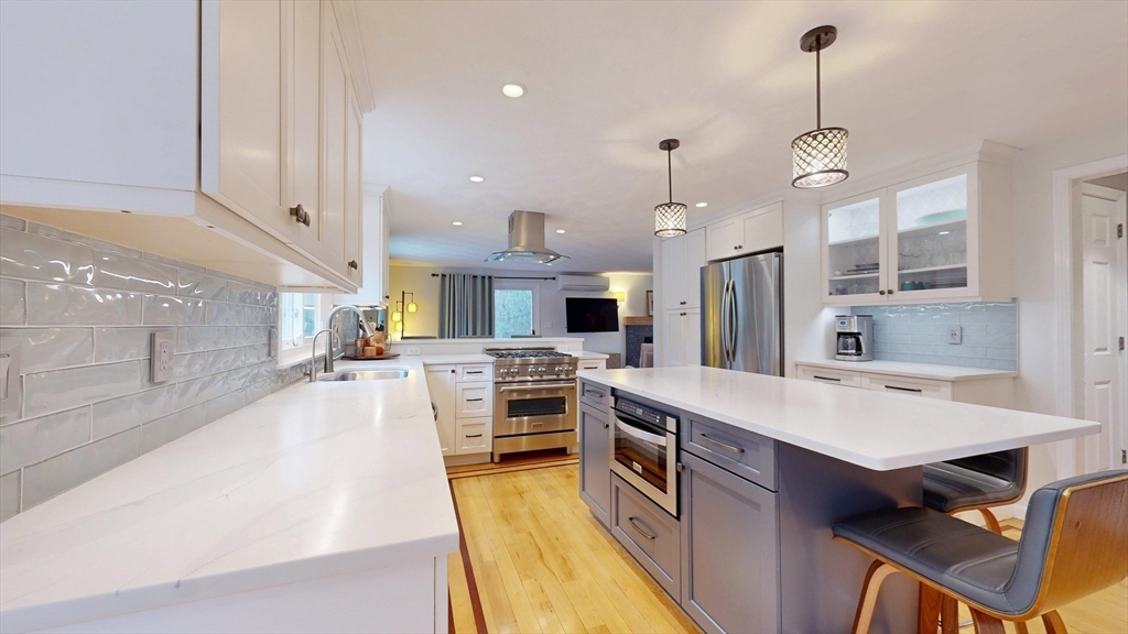 990 Forest Street North Andover, MA 01845 - Photo 17 of 42 a large kitchen with stainless steel appliances a stove a sink a oven a dining table and chairs