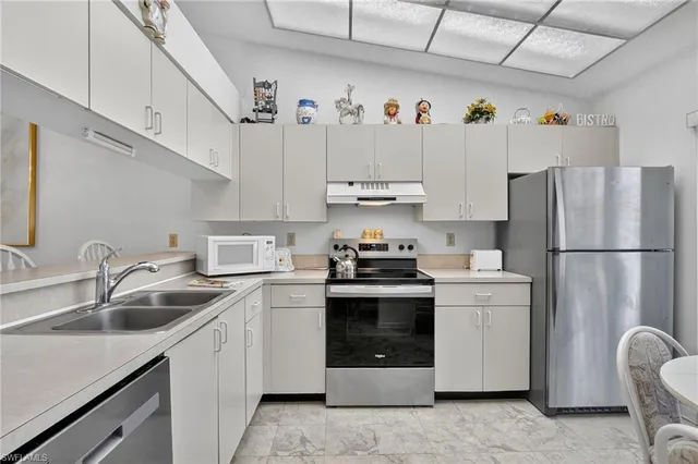 a kitchen with refrigerator a sink and cabinets