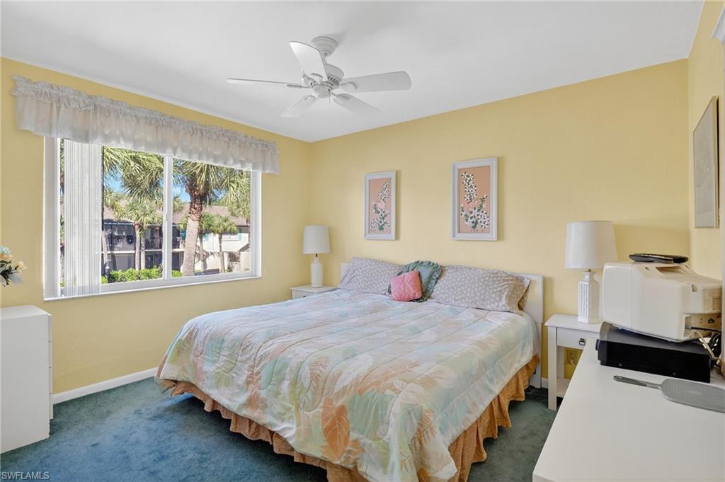 4210 Looking Glass Lane, Unit 4210 Naples, FL 34112 - Photo 14 of 20 a bedroom with a bed and a chandelier