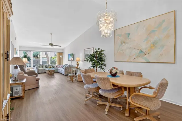 a dining room with furniture a chandelier and wooden floor