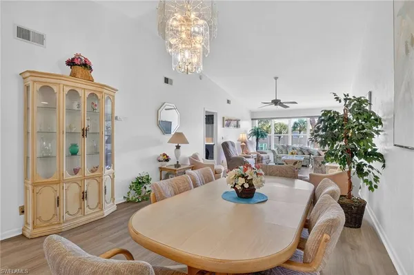 a living room with furniture a chandelier and a dining table