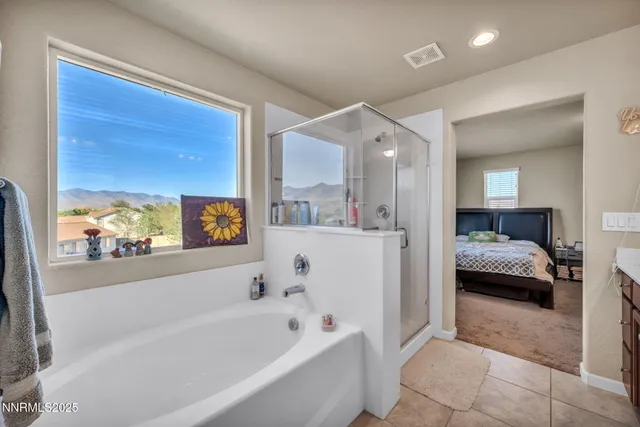 a en suite spacious bathroom with a tub shower and window