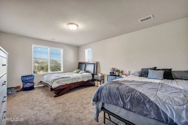 a bedroom with two beds and a window
